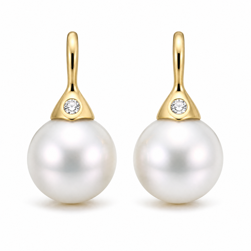 Pearl drop earrings with diamonds in 18K gold on white background